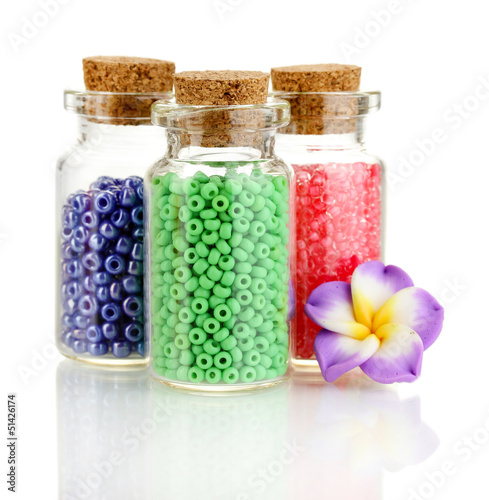 Photo: Little bottles full with colorful beads isolated on white Little bottles full with colorful beads isolated on white