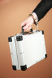Hand with handcuff and suitcase, on color background