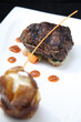 Tenderloin steak portion with potato on black background