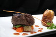 Tenderloin steak portion with potato on black background