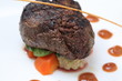 Tenderloin steak portion with potato on black background