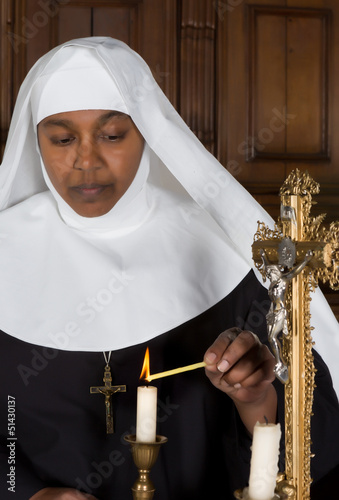 Photo: Nun lighting a candle Nun lighting a candle