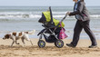Madre con cochecito bebe por la playa