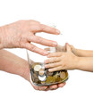 hands elderly and kids over to glass jar with coins