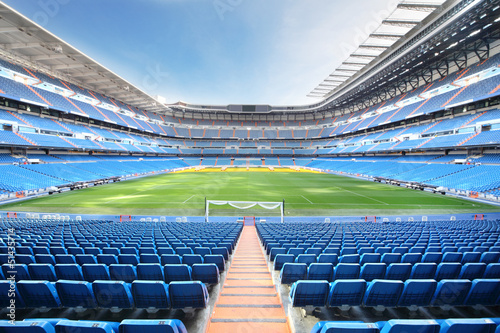 Photo: Empty outdoor football stadium with blue seats Empty outdoor football stadium with blue seats