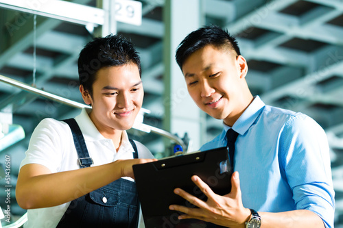 Photo: Worker and production manager with Clipboard Worker and production manager with Clipboard