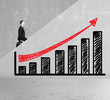 man rises on cocnrete ledder with drawing graph