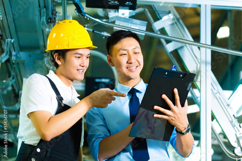 Photo: Worker and production manager with Clipboard Worker and production manager with Clipboard
