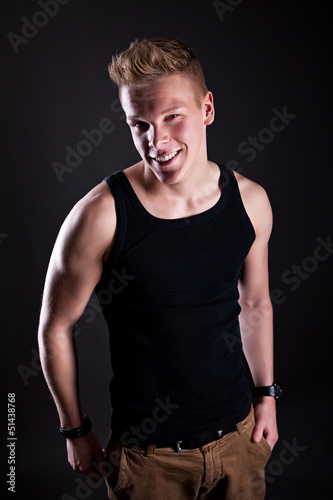 Photo: Muscular sexy smiling young cute man posing in a vest Muscular sexy smiling young cute man posing in a vest