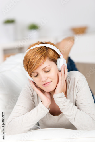 Photo: frau hört musik auf dem sofa frau hört musik auf dem sofa