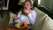 Woman watching tv and eating fruit