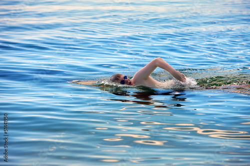 Photo: young sporting man swims in the sea young sporting man swims in the sea