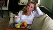 Woman watching tv and eating fruit