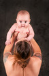 Lovely mom holding her baby up with tattoos