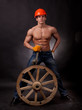 Muscular young man with a wagon wheel on a black background.