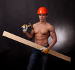 Muscular young worker  with a hammer  on a black background.