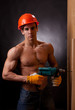Muscular young worker with an electric drill