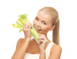woman biting piece of celery or green salad