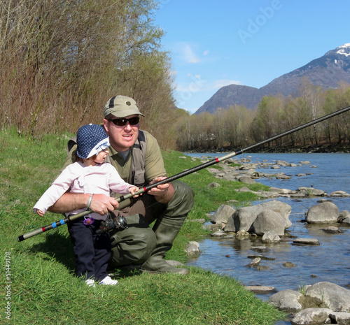 Photo: papà e figlia pescano in riva al fiume papà e figlia pescano in riva al fiume