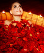 Beautiful girl in jacuzzi with rose petal and candle.