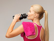 sporty woman drinking water from sportsman bottle