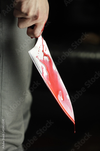 Photo: Man holding bloody knife Man holding bloody knife