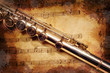 Photo: Silver flute on an ancient musical background Silver flute on an ancient musical background