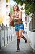 beauty blonde girl with short skirt at playing with mobile phone
