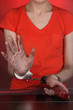 Prisoner in handcuffs behind glass in soundproof room