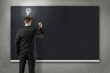 Foto: businessman is writing down ideas on blackboard businessman is writing down ideas on blackboard