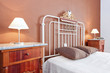 Lampshades near the old classic bed in the bedroom. Brown color.
