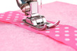 Closeup of sewing machine working part with  pink  cloth