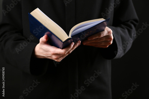 Photo: Priest reading from the holy bible, close up Priest reading from the holy bible, close up