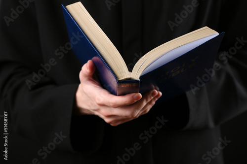 Photo: Priest reading from the holy bible, close up Priest reading from the holy bible, close up