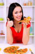 Girl with delicious pizza on kitchen background