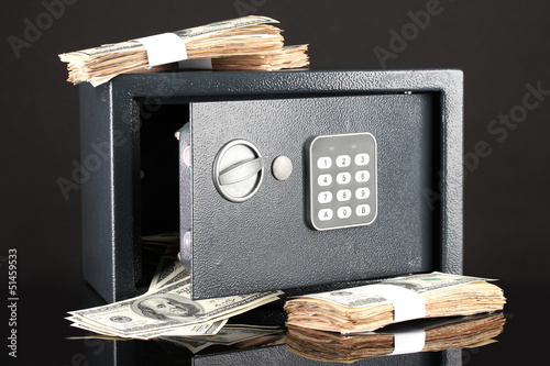 Photo: Money in open safe isolated on black Money in open safe isolated on black