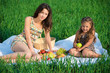 Photo: Happy girls on green grass with fruits Happy girls on green grass with fruits