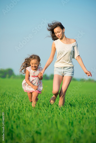 Photo: Young happy girls running at green wheat field Young happy girls running at green wheat field