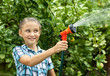 Young girl pours water from hose