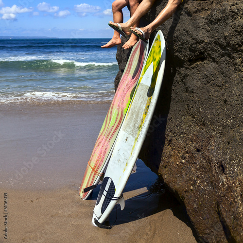Photo: Two friend surfer sitting on rock Two friend surfer sitting on rock