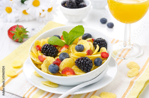 Photo: Cornflakes, fresh berries and orange juice for breakfast Cornflakes, fresh berries and orange juice for breakfast