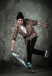Photo: Young man in hat and shirt performing stunt on skateboard Young man in hat and shirt performing stunt on skateboard