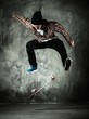 Young man in hat and shirt performing stunt on skateboard