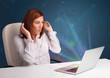 Beautiful woman sitting at desk and typing on laptop with abstra