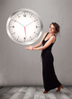 Attractive lady holding a huge clock
