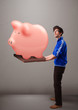 Handsome man holding a huge savings piggy bank