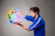 Casual man holding laptop with colorful hand drawn multimedia sy