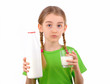 Little girl holding a bottle and  glass of milk