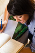 Photo: Girl with pile of books learning Girl with pile of books learning