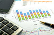 Financial paper charts and graphs with iphone and calculator